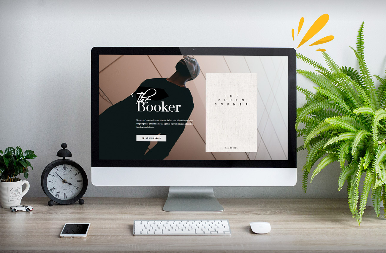 A sleek desktop displays a book website featuring "The Philosopher" by Sam Booker, with a stylish clock and greenery nearby.